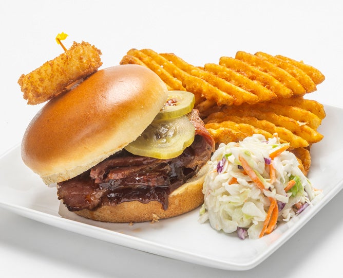 BBQ sandwich with onion ring, crisscut fries, and coleslaw